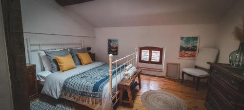 1 dormitorio con 1 cama, 1 silla y 1 ventana en Le Bezy Pyrénées, en Mézerville