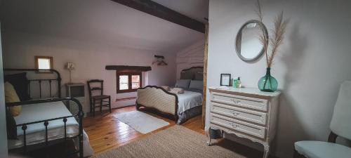 1 dormitorio con cama, tocador y espejo en Le Bezy Pyrénées, en Mézerville