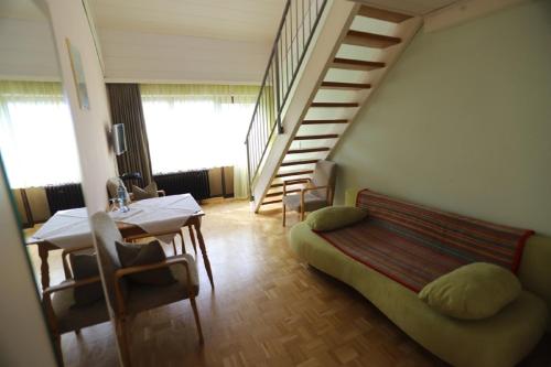 a room with a staircase and a bed and a table at Gasthof - Pension Krämerhof in Thanstein