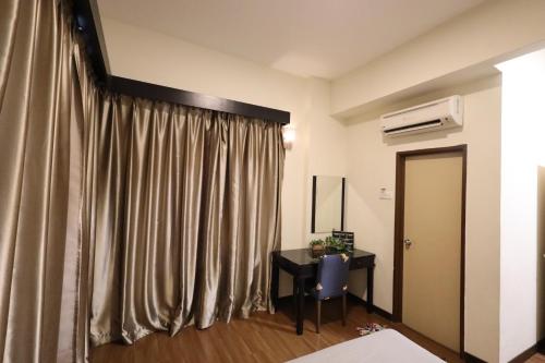a room with a curtain and a table and a desk at TOP 1 family trip relax resort in melaka pecuma water park tiket in Melaka