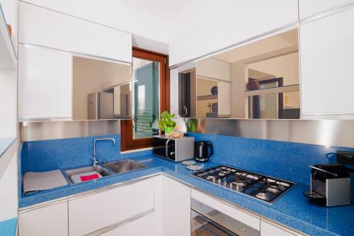 La cuisine est équipée d'un évier et d'un comptoir bleu. dans l'établissement Leukasia, à Marina di Pescoluse