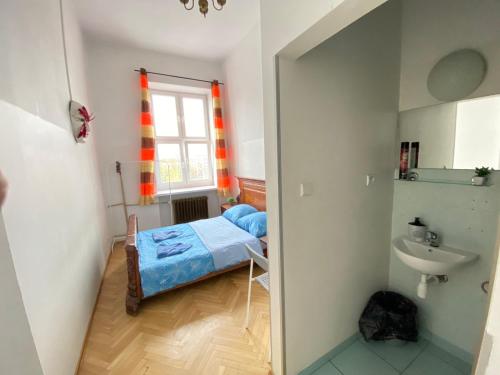 Habitación pequeña con cama y lavamanos en Oliwka Hostel, en Varsovia