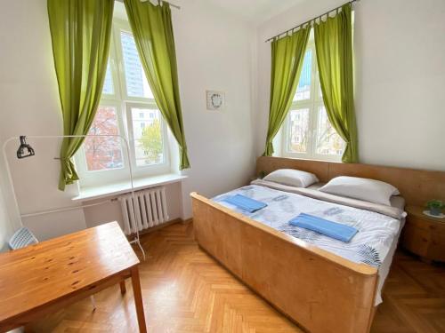 a bedroom with a large bed with green curtains at Oliwka Hostel in Warsaw