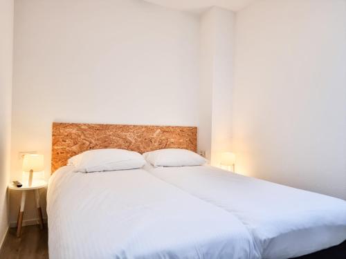 ein Schlafzimmer mit einem großen weißen Bett mit zwei Kissen in der Unterkunft Studio Hello Domburg 2 DO40 in Domburg