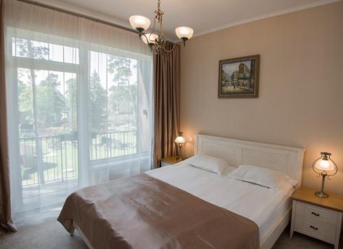 a bedroom with a bed and a large window at Dzintari in Jūrmala