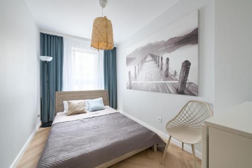 a bedroom with a bed and a painting on the wall at Happy Stay Comfort Apartment By the Beach in Sopot
