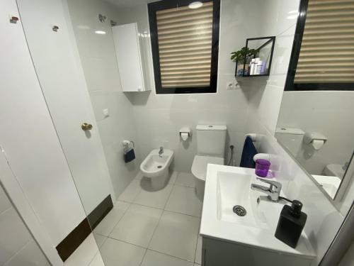 biała łazienka z umywalką i toaletą w obiekcie A28 - Frontmar - 2004 Finestrat s.l. w mieście Cala de Finestrat