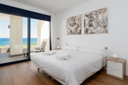 um quarto branco com uma cama e vista para o oceano em 2226-Luxury sea view apartment em La Alcaidesa