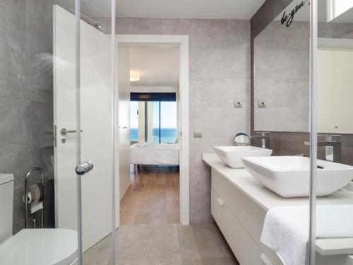 uma casa de banho com 2 lavatórios brancos e um chuveiro em 2226-Luxury sea view apartment em La Alcaidesa