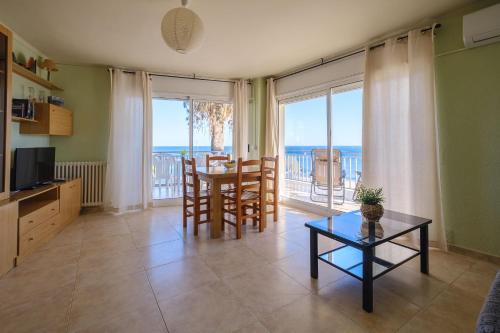 a living room with a table and a view of the ocean at Deauville Miami platja in Miami Platja