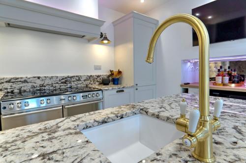 a kitchen with a marble counter top and a gold faucet at The Tannochbrae in Dufftown