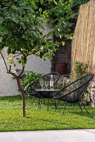 a table and two chairs with wine glasses on it at Erotokritos City Luxury Suites in Rethymno Town