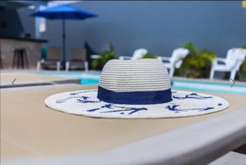 a hat sitting on a table next to a pool at Bida Marino Residence Aruba in Palm-Eagle Beach