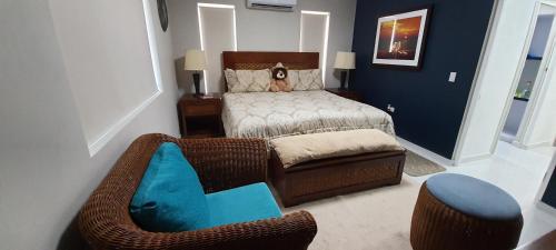 a small bedroom with a bed and a chair at Bida Marino Residence Aruba in Palm-Eagle Beach