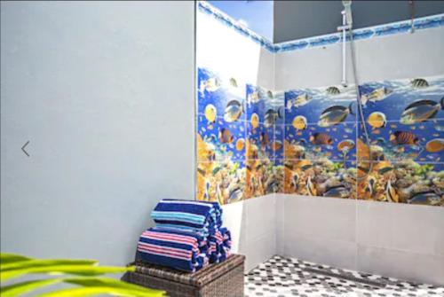 a bathroom with a fish mural on the wall at Bida Marino Residence Aruba in Palm-Eagle Beach