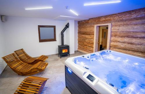 a bathroom with a hot tub and a stove at Rezort pri jazere Podbanské in Pribylina