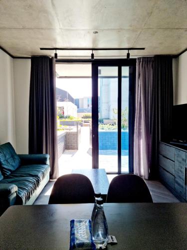 salon z kanapą i stołem w obiekcie Bridgewater One by Smart City Stays w Kapsztadzie
