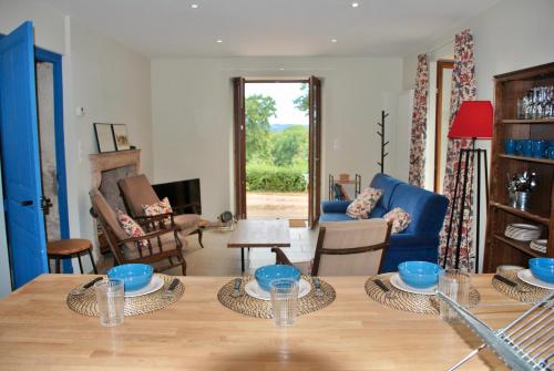 a living room with a table and blue chairs at Maison de la Tour in Étang-sur-Arroux
