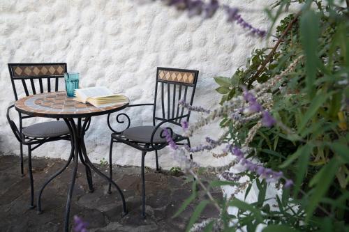 Dos sillas y una mesa con un libro. en La Piedra Blanca, en San Sebastián de la Gomera