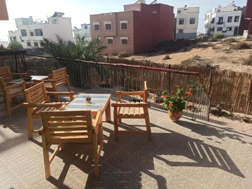 a patio with a table and chairs and a fence at Dar Mouja, eco-friendly home in Imsouane