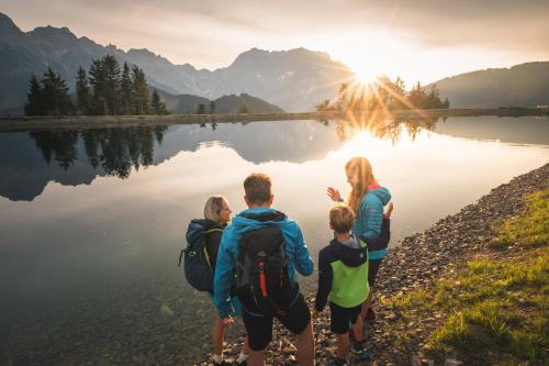 a group of people standing on the shore of a lake at UR-NATUR Appartements in Maria Alm am Steinernen Meer