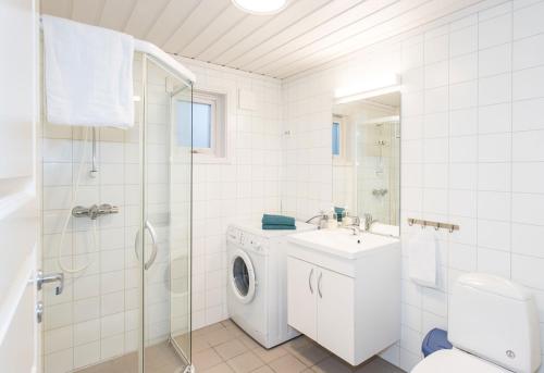 uma casa de banho branca com uma máquina de lavar roupa e um lavatório em Topcamp Sjøsanden - Mandal em Mandal