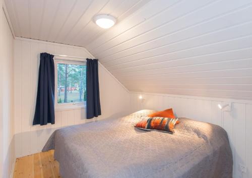 Cama en habitación pequeña con ventana en Topcamp Sjøsanden - Mandal, en Mandal