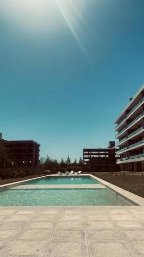 an empty swimming pool with the sun in the sky at Delicado loft amplio y de diseño in Rosario