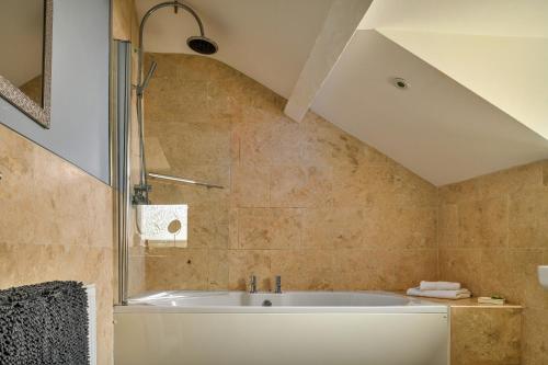 a bathroom with a tub and a shower at Finest Retreats - Bodlawen Holiday House - Edge of Snowdonia in Cerrig-y-Druidion