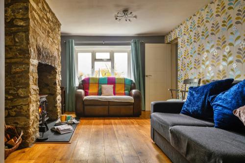 Finest Retreats - Bodlawen Holiday House - Edge of Snowdonia في Cerrig-y-Druidion: غرفة معيشة مع أريكة وكرسي