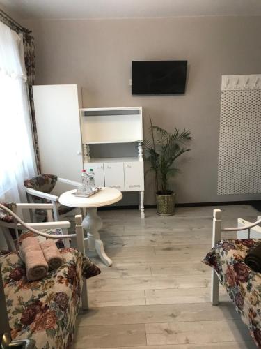 een woonkamer met een tafel en een televisie bij Villa Galicia in Berehove