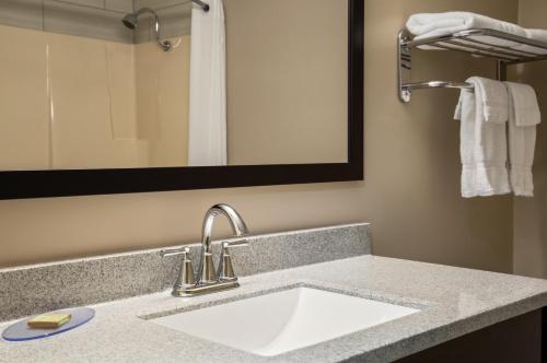 a bathroom with a sink and a mirror at Super 8 by Wyndham Timmins ON in Timmins