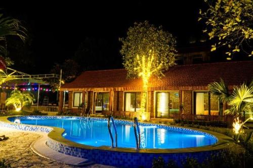 a swimming pool in front of a house at night at D&D riverside Homestay in Xuân Sơn