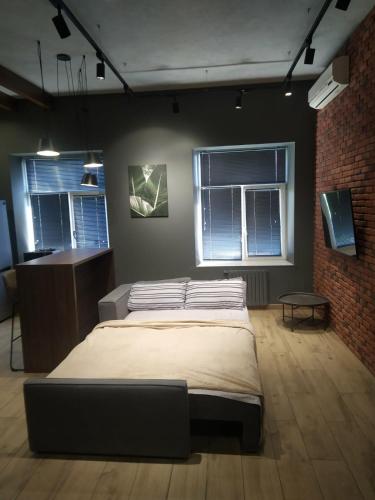 a bedroom with a large bed and two windows at Deribasovskaya 18 Loft in Odesa