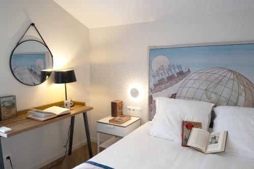 a bedroom with a bed and a desk with a mirror at Hôtel Jules Verne Biarritz in Biarritz