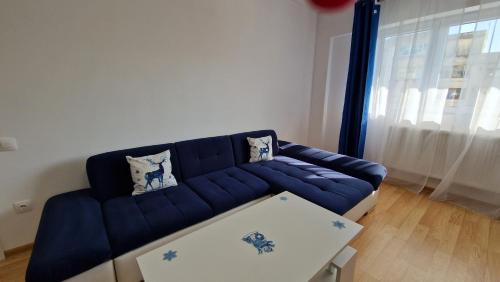 un divano blu in soggiorno con tavolo di Best Apart Garii a Braşov
