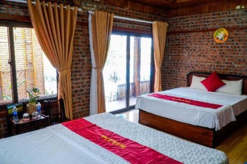 a bedroom with two beds and a brick wall at D&D riverside Homestay in Xuân Sơn