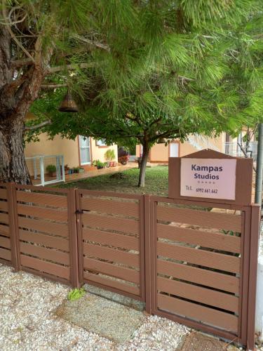 a wooden fence with a sign that reads kennys suicide at Kampas studios in Agios Georgios