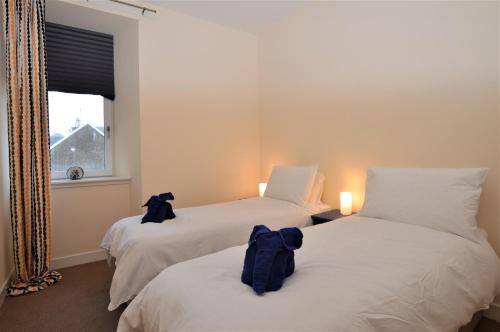 a room with two beds with backpacks on them at Pedals and Paddles in Innellan