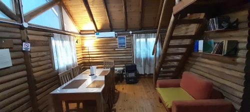 Habitación con escritorio y escalera en una cabaña de madera. en Cabana Mamull en La Consulta