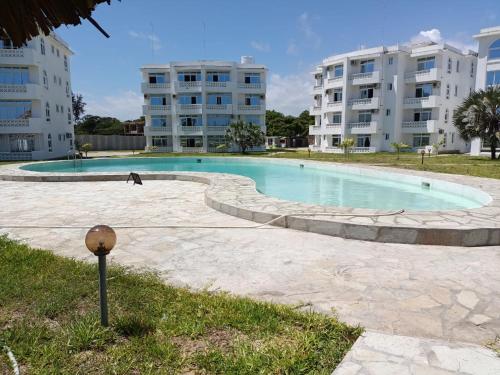 a swimming pool in front of some apartment buildings at PahaliMzuri Kijani - 1 Bedroom Beach Apartment with Swimming Pool in Malindi