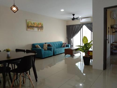 a living room with a blue couch and a table at KH Water Park Manhattan Condo Ipoh Homestay in Kampong Pinji