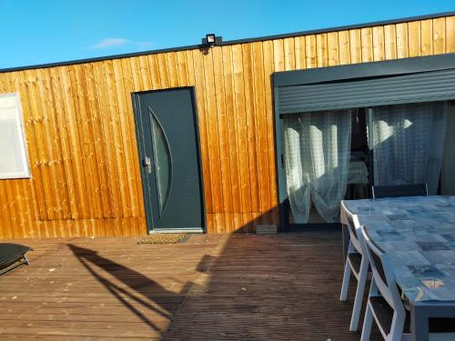 a patio with a green door and a table with chairs at logement atypique in Arles