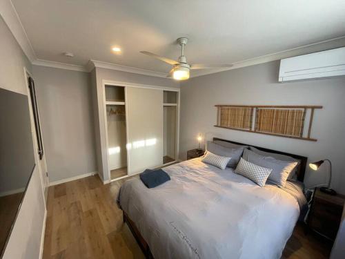 a bedroom with a large bed with a ceiling fan at Peaceful North Lakes Haven w A Touch of Zen in North Lakes