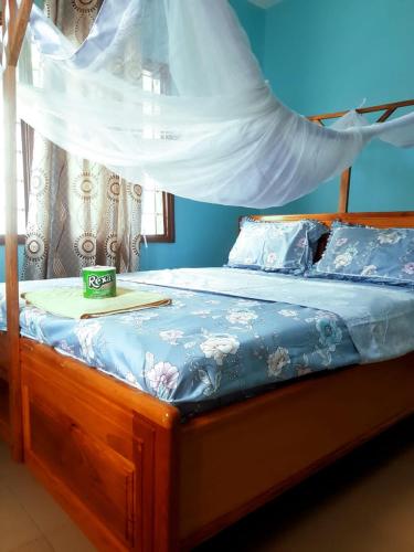 a bed with a wooden frame with a canopy at Cozy Master bedroom with Free Wi-Fi in Tanga in Tanga