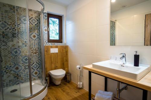 La salle de bains est pourvue d'un lavabo, d'une douche et de toilettes. dans l'établissement Rezort pri jazere Podbanské, à Pribylina