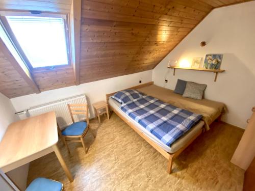 um quarto com uma cama, uma mesa e uma janela em Ubytko Ivko em Letohrad