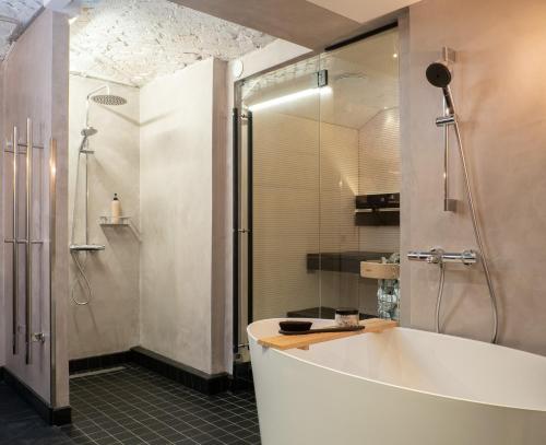 a bathroom with a large tub and a shower at Bob W Koti Katajanokka in Helsinki