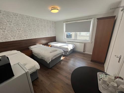 a small room with two beds and a window at Park View Rooms in Edinburgh