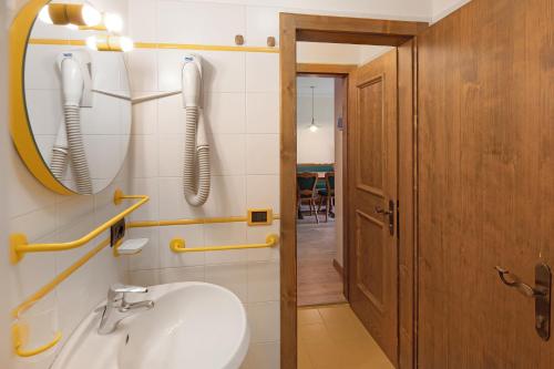 W łazience znajduje się umywalka, lustro i telefon. w obiekcie Casa San Marco n 7 w Livigno